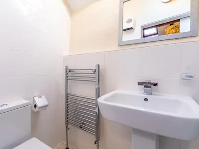 a white bathroom with a sink and a mirror at 1 Bed in Helston oc-41377 in Cury