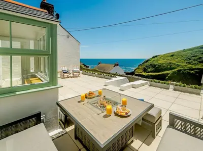 a patio with a table with food and orange candles at 3 Bed in Truro oc-87260 in Portloe