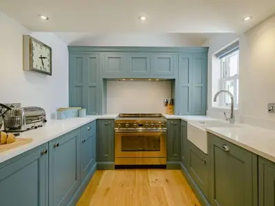 a kitchen with blue cabinets and a stove top oven at 3 Bed in Truro oc-87260 in Portloe