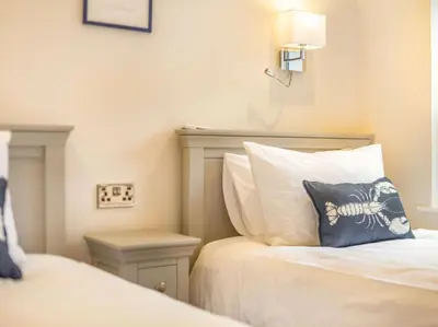 a bedroom with two beds and a pillow on the bed at 3 Bed in Truro oc-87260 in Portloe