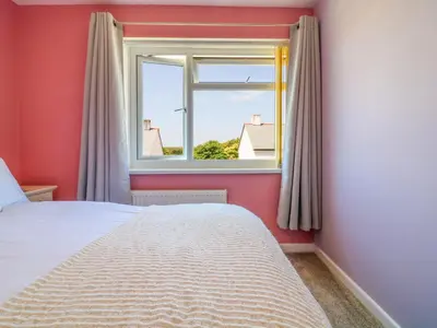 a bedroom with a bed and a window at Cres in Tintagel
