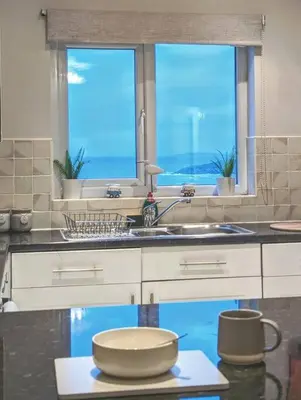 a kitchen with a sink and a window at Fistral beachside escape - dramatic ocean views in Crantock