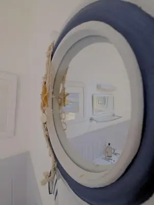 a mirror in a bathroom with a sink at Fistral beachside escape - dramatic ocean views in Crantock
