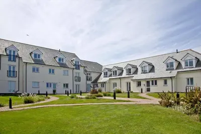 a row of houses with a green lawn at Fistral beachside escape - dramatic ocean views in Crantock
