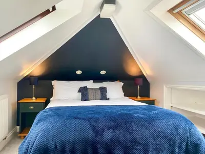 a bedroom with a blue bed in a attic at 1 Bed in Nr Bude oc-penke in Saint Gennys