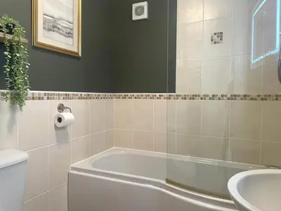 a bathroom with a tub and a toilet and a sink at 1 Bed in Nr Bude oc-penke in Saint Gennys