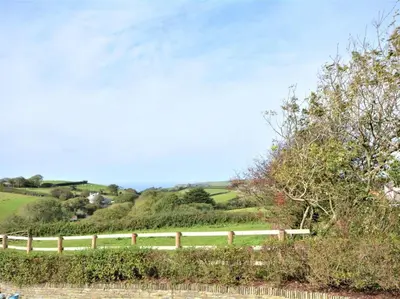 a white fence in the middle of a field at 1 Bed in Nr Bude oc-penke in Saint Gennys