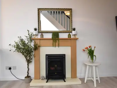 a fireplace with a mirror on top of it at 1 Bed in Nr Bude oc-penke in Saint Gennys