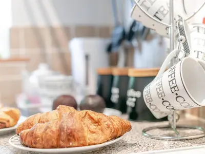 a plate of croissants on a counter with a mixer at 1 Bed in Bude oc-tchawth in Saint Gennys