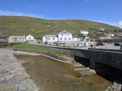 a bridge over a river with houses on a hill at 1 Bed in Bude oc-tchawth in Saint Gennys