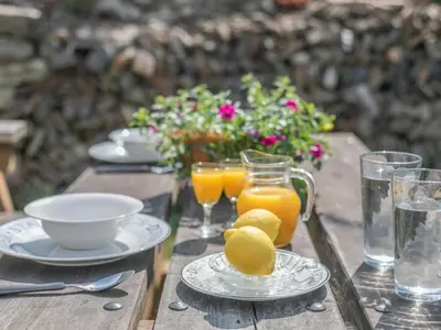 a table with a plate of lemons and glasses of orange juice at 1 Bed in Bude oc-tchawth in Saint Gennys