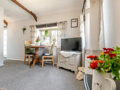 a living room with a large television and a table at 1 Bed in Bude oc-tchawth in Saint Gennys