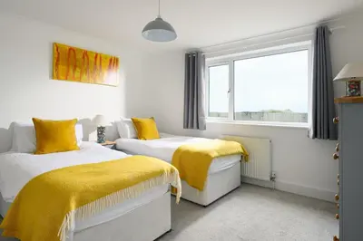 two beds in a room with yellow blankets at Mermaid Gaze in Porth, Newquay in Newquay