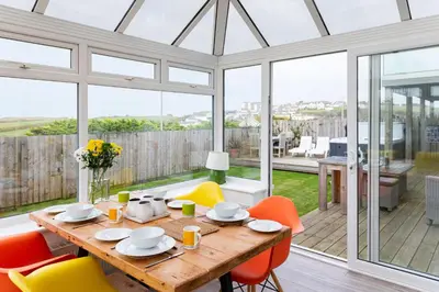 a dining room with a table and chairs at Mermaid Gaze in Porth, Newquay in Newquay