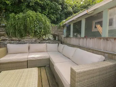 a white couch sitting on top of a patio at Blacksmiths Cottage in Newquay