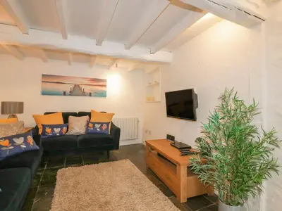 a living room with a couch and a tv at Blacksmiths Cottage in Newquay