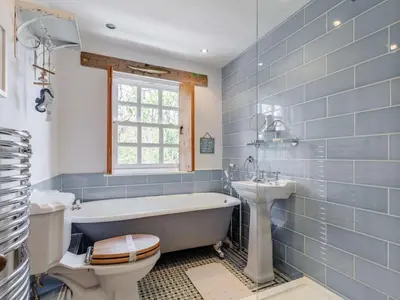 a bathroom with a tub and a toilet and a sink at 2 Bed in Wadebridge oc-82682 in Little Petherick