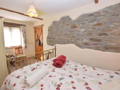 a bed in a bedroom with a stone wall at 2 Bed in Launceston oc-congs in North Hill