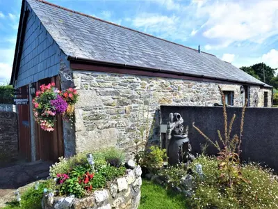 an old stone building with a statue in a garden at 2 Bed in Launceston oc-congs in North Hill