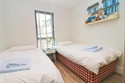 two twin beds in a room with a window at Stylish townhouse in Padstow in Padstow