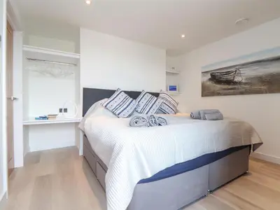 a bedroom with a bed and a painting on the wall at Sailors in Falmouth