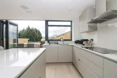 a kitchen with white counters and a large window at Sailors in Falmouth