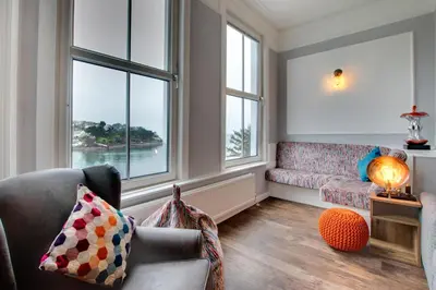 a living room with a couch and two windows at 3 Bed in Fowey oc-p00803 in Fowey