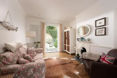 a living room with a couch and a fireplace at La Folie, Fowey in Fowey