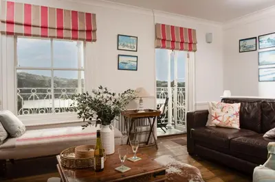 a living room with a couch and a table at La Folie, Fowey in Fowey
