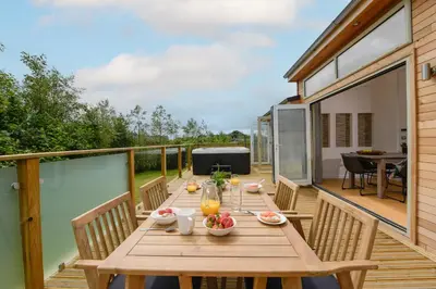 a wooden deck with a wooden table and chairs at 5 Southern Place in Liskeard
