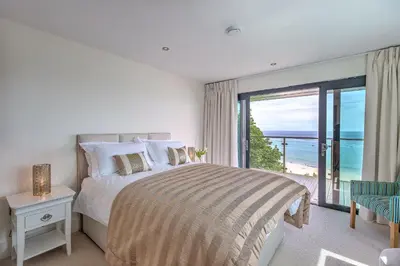 a bedroom with a bed and a view of the ocean at Abalone in St Ives