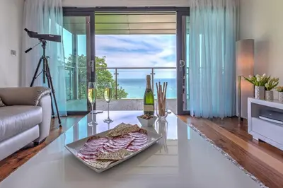 a living room with a glass table with food and wine at Abalone in St Ives