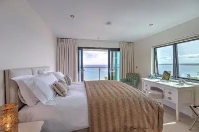 a bedroom with a bed and a desk with a window at Abalone in St Ives