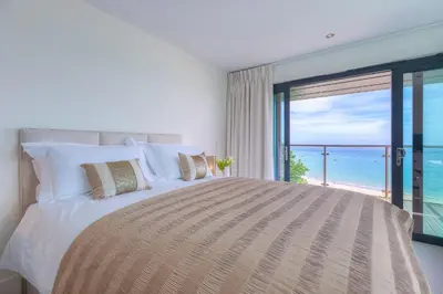 a bedroom with a large bed with a view of the ocean at Abalone in St Ives