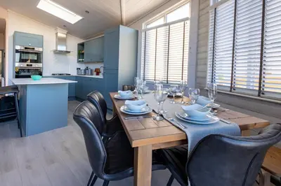 a dining room with a wooden table and chairs at Gull Rocks Beach Lodges in Cubert