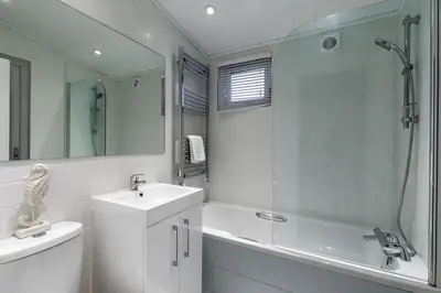 a bathroom with a sink and a tub and a shower at Gull Rocks Beach Lodges in Cubert