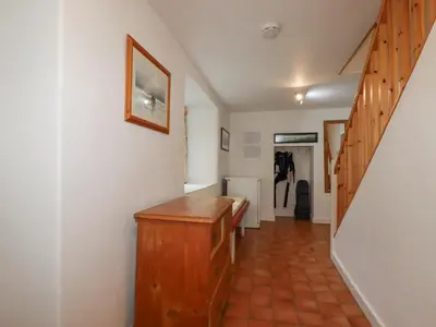 a hallway with a wooden desk in a room at Trewillig Cottage in Wadebridge