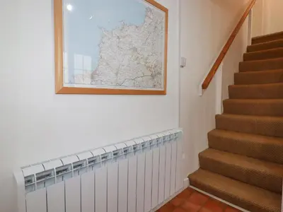 a picture of a map on a wall next to a staircase at Trewillig Cottage in Wadebridge