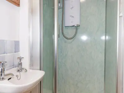 a bathroom with a shower and a sink at Trewillig Cottage in Wadebridge