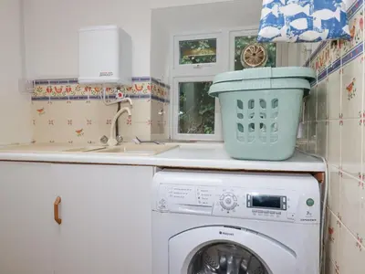a washing machine in a kitchen with a sink at Trewillig Cottage in Wadebridge