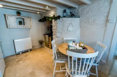 a dining room with a wooden table and chairs at Boscastle Quaint Cornish Fishermans Cottage in Boscastle