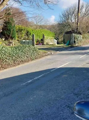 an empty road with a car parked on the side at Boscastle Quaint Cornish Fishermans Cottage in Boscastle