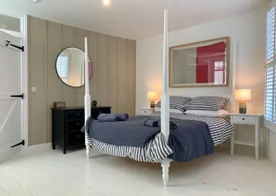 a bedroom with two beds and a mirror at Luxurious cottage in the heart of Falmouth in Falmouth