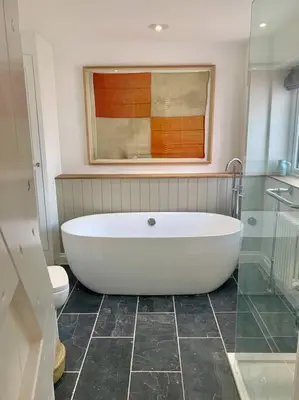a bathroom with a large white tub and a toilet at Luxurious cottage in the heart of Falmouth in Falmouth