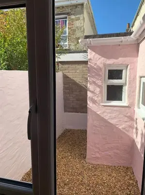 a view of a pink house through a door at Luxurious cottage in the heart of Falmouth in Falmouth