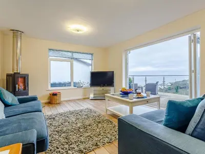 a living room with a blue couch and a tv at 2 Bed in Torpoint oc-75402 in Downderry