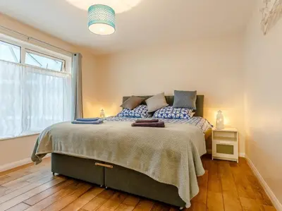 a bedroom with a bed and a large window at 2 Bed in Torpoint oc-75402 in Downderry