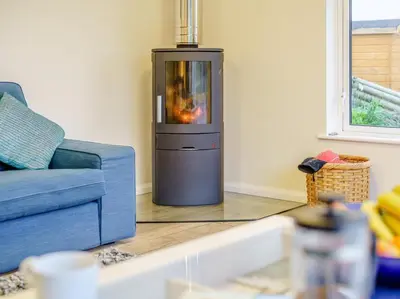 a living room with a blue couch and a fireplace at 2 Bed in Torpoint oc-75402 in Downderry