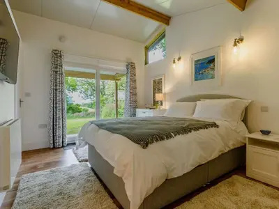 a bedroom with a large bed and a window at 1 Bed in Looe oc-88434 in Lanreath
