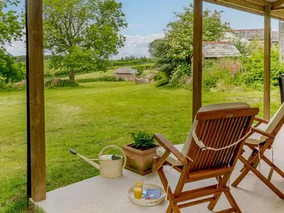 a rocking chair on a porch with a view of a yard at 1 Bed in Looe oc-88434 in Lanreath